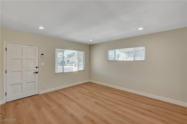 foyer featuring light wood-style floors, baseboards, and recessed lighting