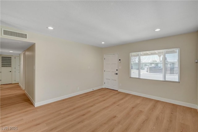 empty room with light wood-type flooring, baseboards, and recessed lighting