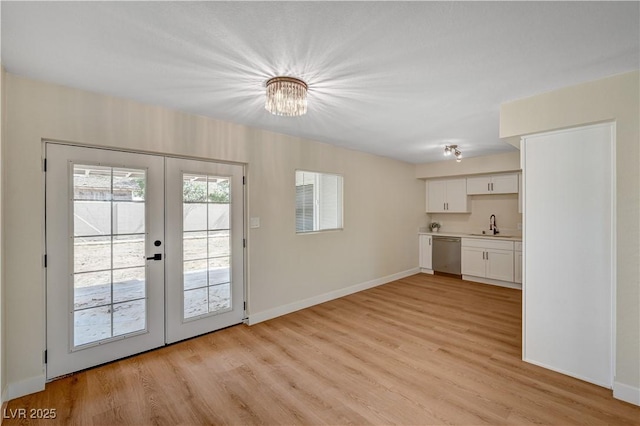 entryway with french doors, light wood-style floors, a sink, baseboards, and a chandelier