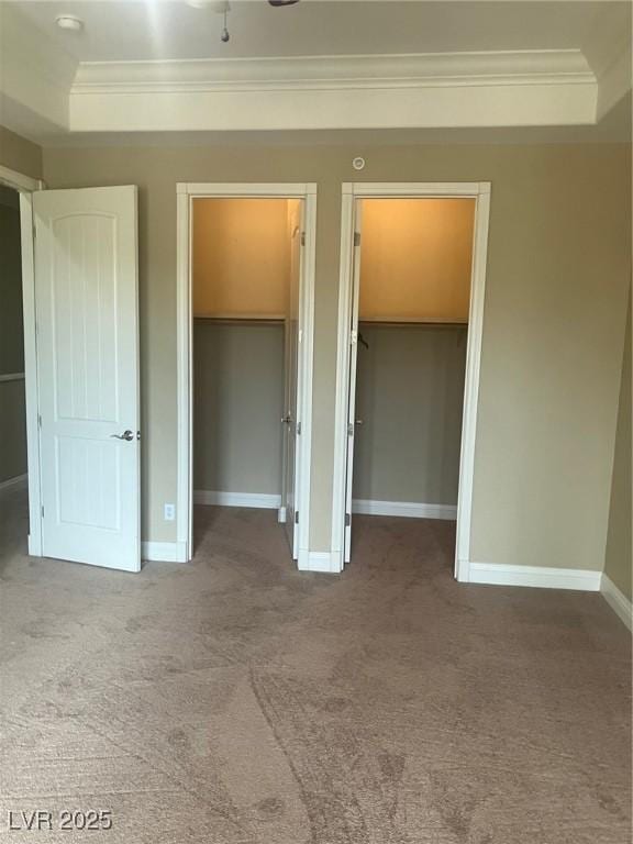 32 Via Vasari Unit 103, Henderson, NV 89011 - unfurnished bedroom with a tray ceiling, crown molding, carpet flooring, and multiple closets