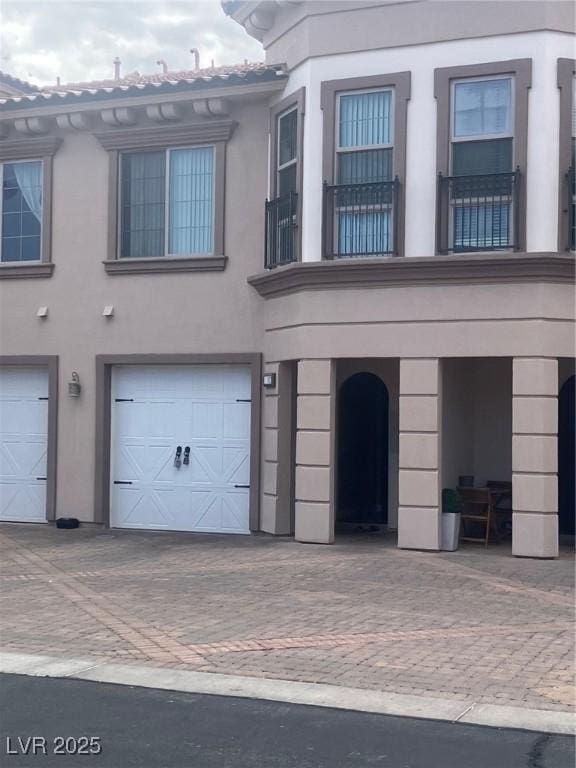 32 Via Vasari Unit 103, Henderson, NV 89011 - view of front facade with stucco siding, driveway, and a garage