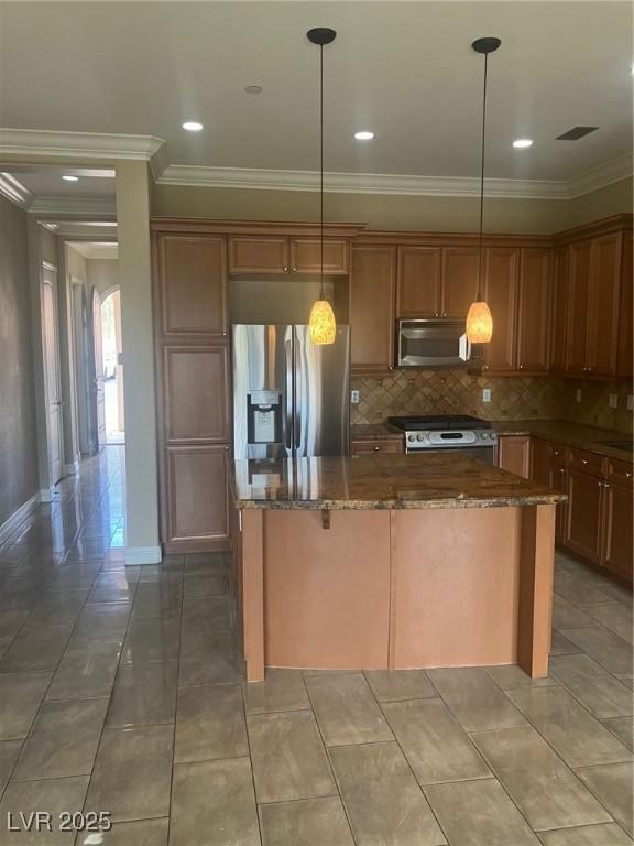 32 Via Vasari Unit 103, Henderson, NV 89011 - kitchen with ornamental molding, a center island, dark stone counters, and appliances with stainless steel finishes
