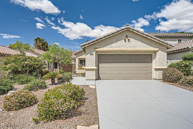 view of front of house with a garage, stucco siding, and driveway