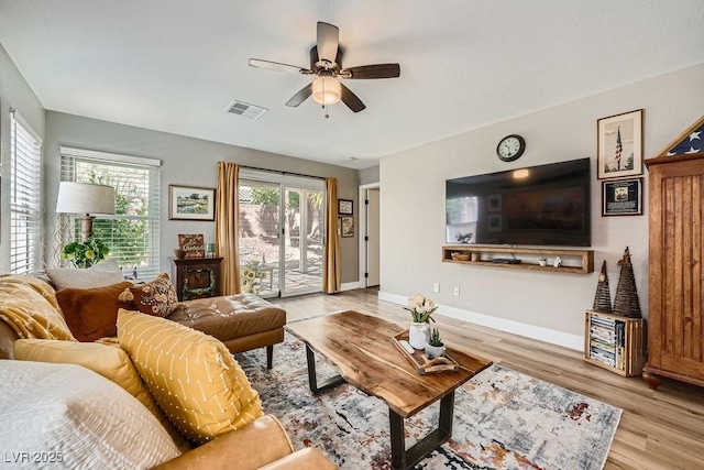living area with a ceiling fan, baseboards, visible vents, and wood finished floors
