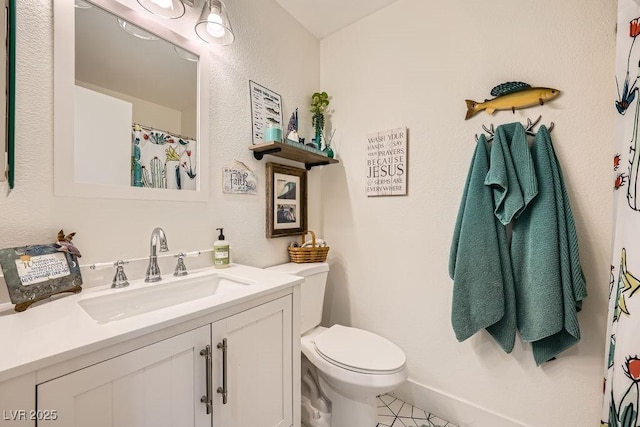 bathroom with toilet, tile patterned floors, baseboards, and vanity