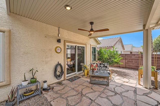 view of patio with ceiling fan and fence