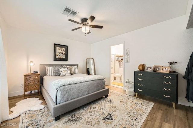 bedroom featuring visible vents, wood finished floors, and ensuite bathroom