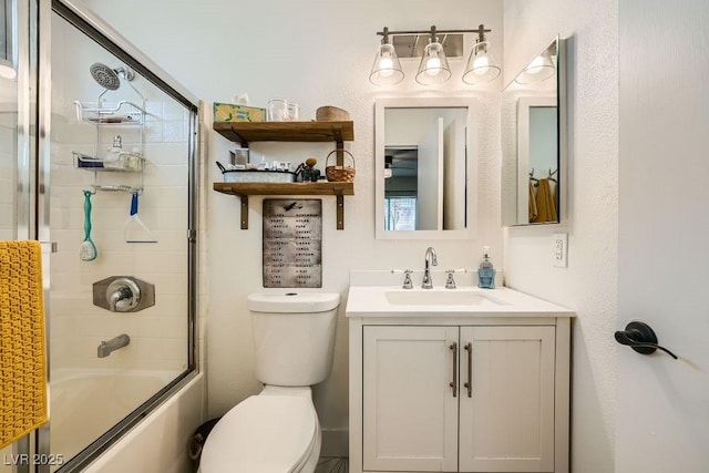 bathroom featuring vanity, enclosed tub / shower combo, and toilet