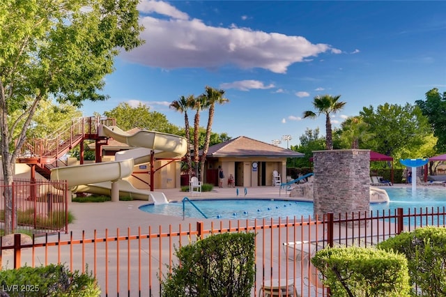 community pool with fence, a water slide, a patio, and playground community