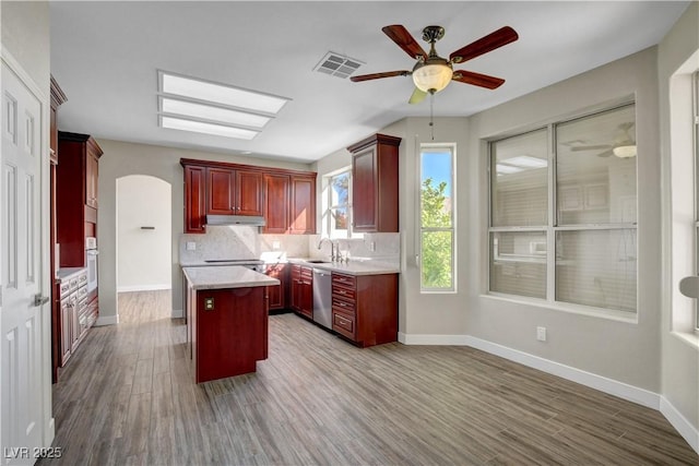 kitchen featuring visible vents, stainless steel dishwasher, dark brown cabinets, ceiling fan, and a sink