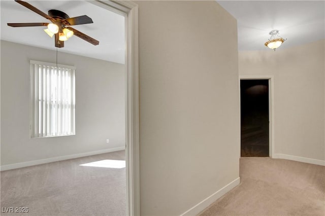 hallway featuring baseboards and carpet