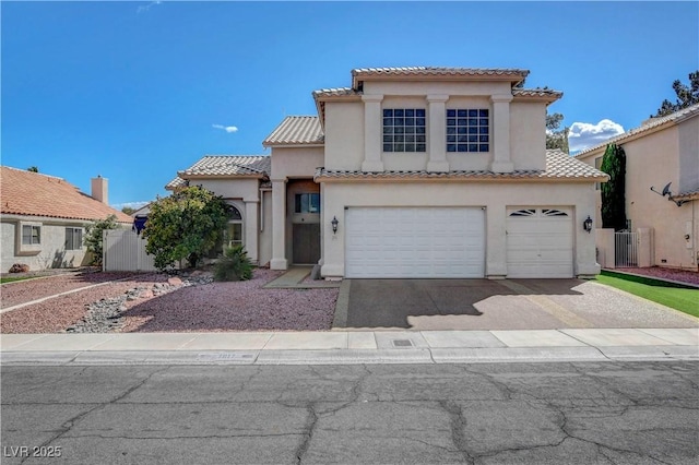 mediterranean / spanish-style home with a tiled roof, an attached garage, driveway, and stucco siding