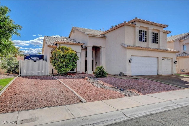 mediterranean / spanish-style home with a tile roof, a garage, a gate, and stucco siding