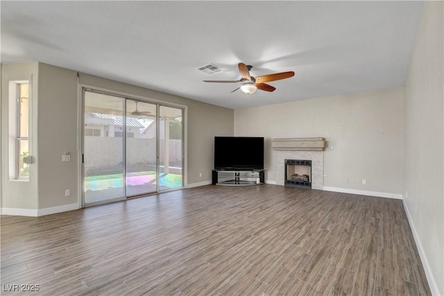 unfurnished living room featuring baseboards, ceiling fan, wood finished floors, and visible vents
