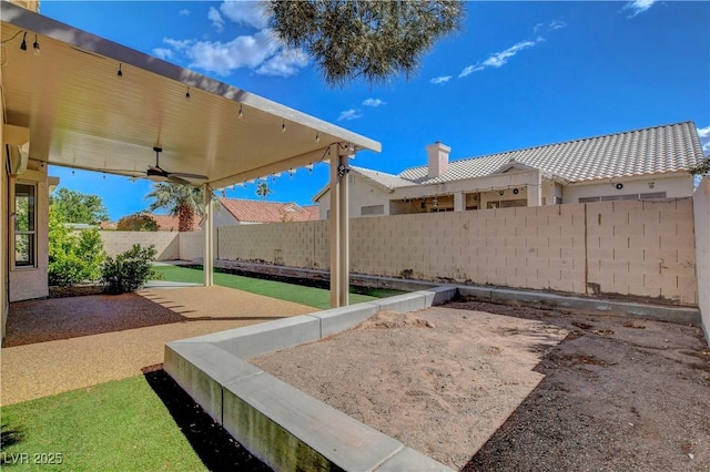 view of yard featuring a fenced backyard, ceiling fan, and a patio area