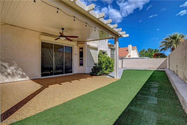 view of yard with a fenced backyard and ceiling fan