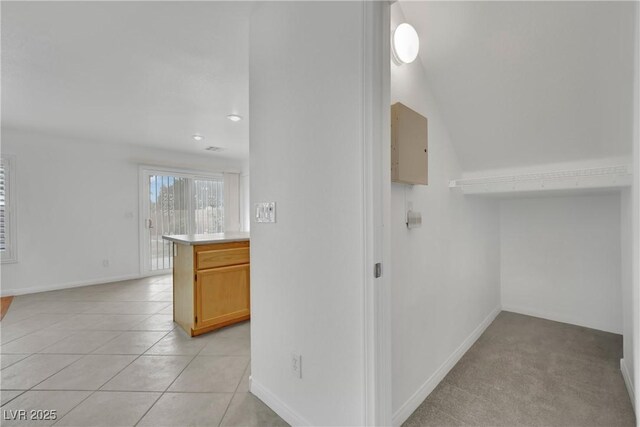 corridor with baseboards, recessed lighting, and light tile patterned floors
