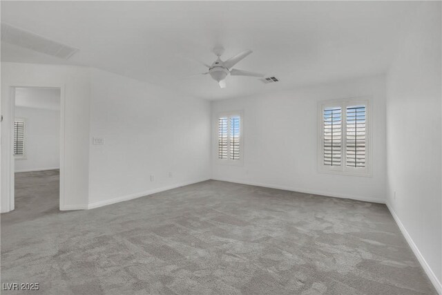 empty room with visible vents, carpet flooring, baseboards, and ceiling fan