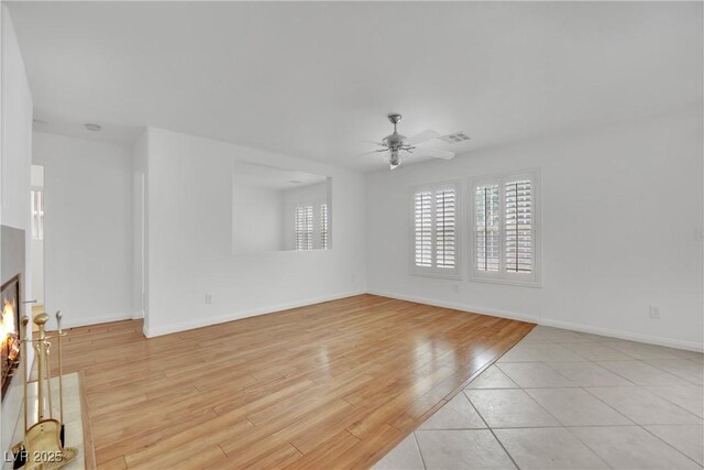 unfurnished living room with baseboards, ceiling fan, light wood finished floors, and visible vents