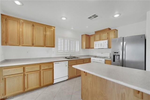 kitchen with visible vents, a sink, light countertops, white appliances, and light tile patterned flooring