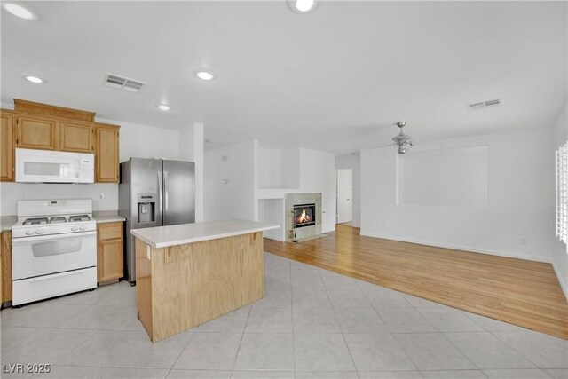kitchen featuring white appliances, light tile patterned flooring, visible vents, and light countertops