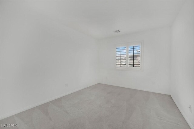 carpeted empty room featuring baseboards and visible vents