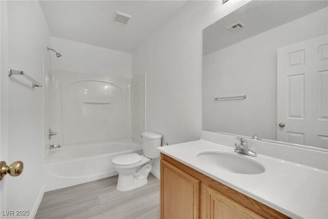 bathroom with visible vents, wood finished floors, toilet, and vanity
