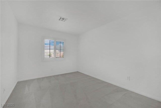 empty room with carpet floors, baseboards, and visible vents
