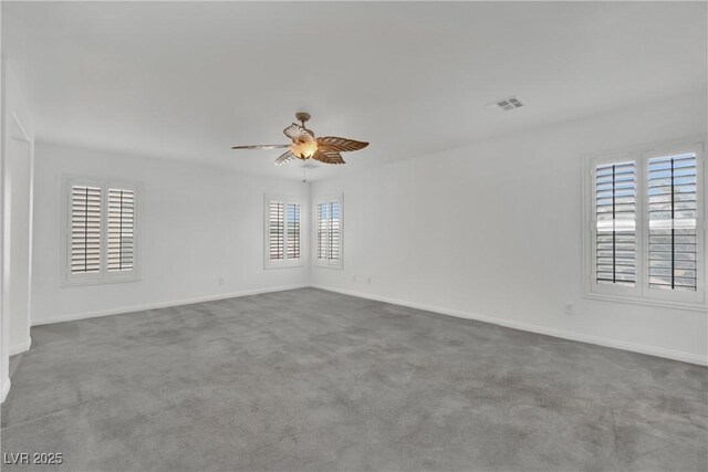 carpeted empty room with baseboards, ceiling fan, and visible vents