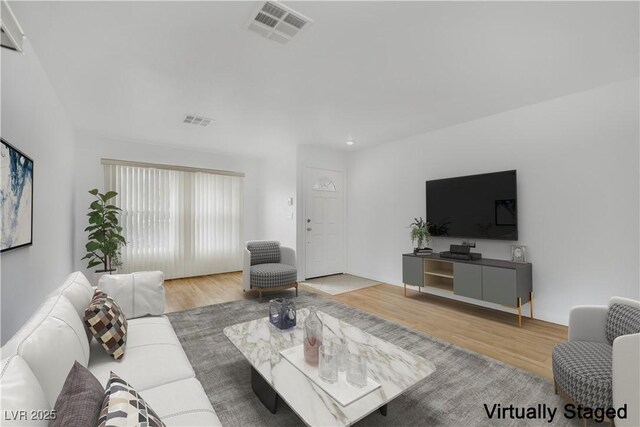 living room with visible vents and wood finished floors