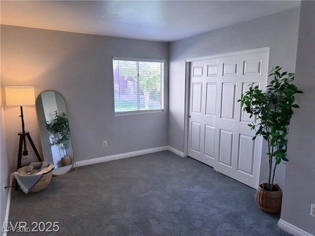4965 Indian River Dr Unit 101, Las Vegas, NV 89103 - unfurnished bedroom with dark colored carpet, baseboards, and a closet