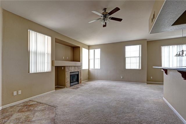 1608 Sussex St Unit 204, Las Vegas, NV 89144 - unfurnished living room with baseboards, ceiling fan, a tile fireplace, and light colored carpet