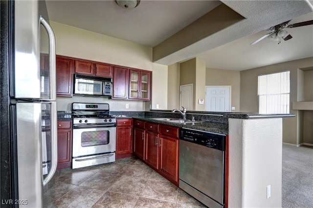 1608 Sussex St Unit 204, Las Vegas, NV 89144 - kitchen featuring appliances with stainless steel finishes, a sink, a peninsula, a ceiling fan, and reddish brown cabinets