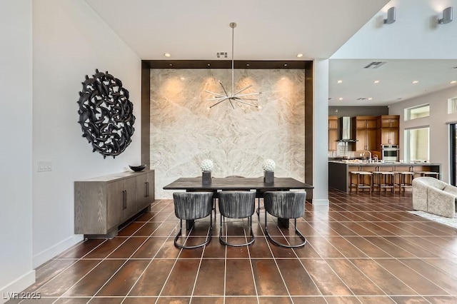 dining space with baseboards, an accent wall, recessed lighting, and visible vents