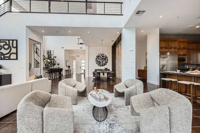living area with a high ceiling, recessed lighting, a chandelier, and visible vents