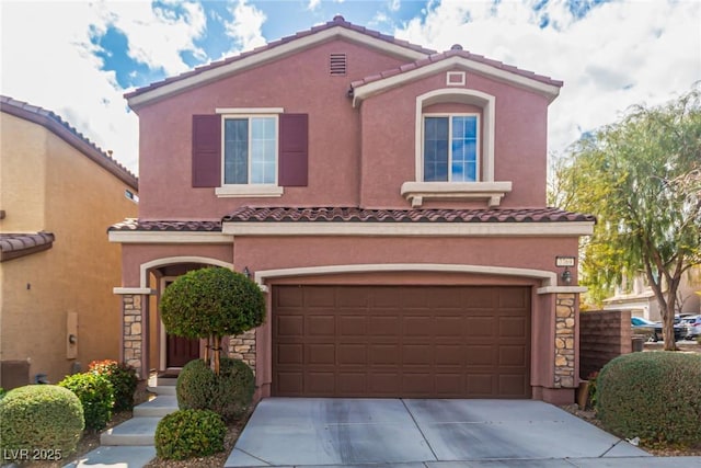 mediterranean / spanish-style house with an attached garage, a tile roof, stone siding, stucco siding, and concrete driveway