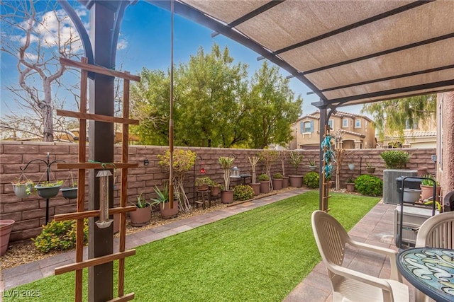 view of yard featuring a fenced backyard, a patio area, and central AC