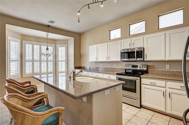 1574 Livingston Dr, Henderson, NV 89012 - kitchen featuring stainless steel appliances, white cabinetry, light tile patterned flooring, and light stone countertops