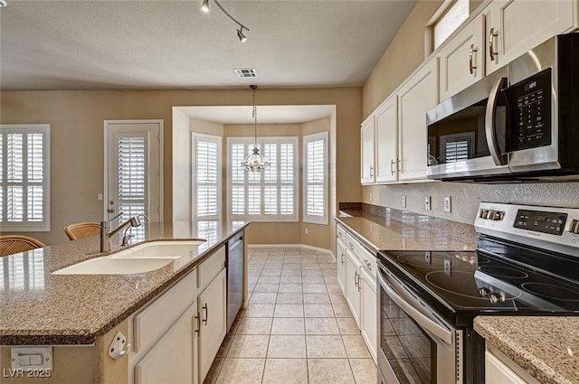1574 Livingston Dr, Henderson, NV 89012 - kitchen featuring appliances with stainless steel finishes, hanging light fixtures, light tile patterned floors, a chandelier, and light stone counters