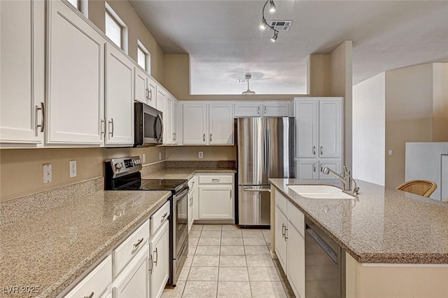 1574 Livingston Dr, Henderson, NV 89012 - kitchen with stainless steel appliances, white cabinetry, light stone counters, and light tile patterned floors