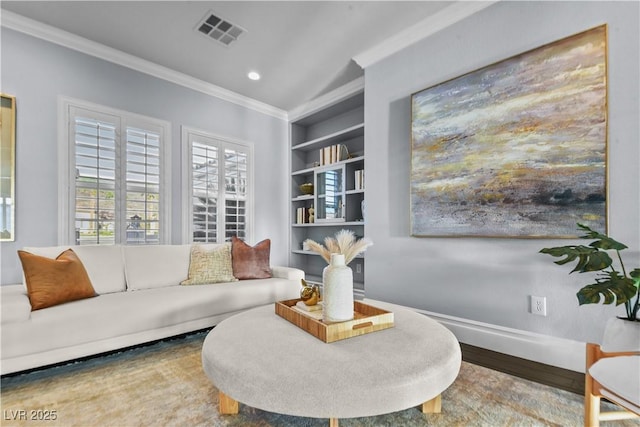 living area featuring visible vents, crown molding, wood finished floors, baseboards, and built in shelves