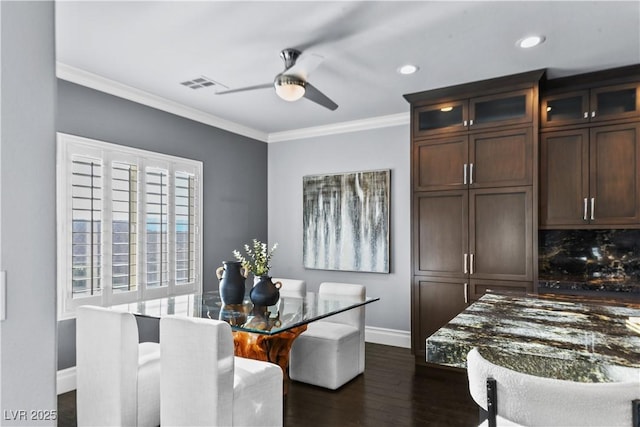 dining space featuring baseboards, ornamental molding, a ceiling fan, and dark wood-style flooring