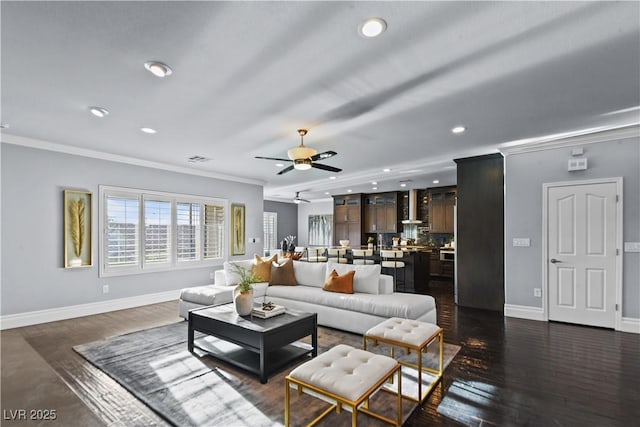 living area featuring baseboards, ornamental molding, and recessed lighting