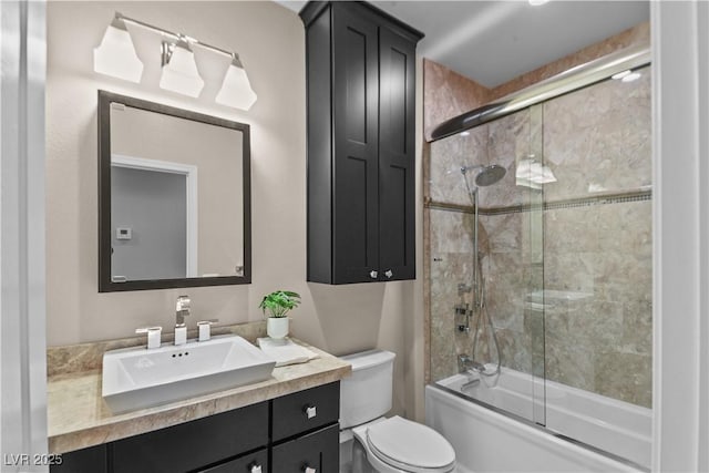 bathroom with toilet, bath / shower combo with glass door, and vanity