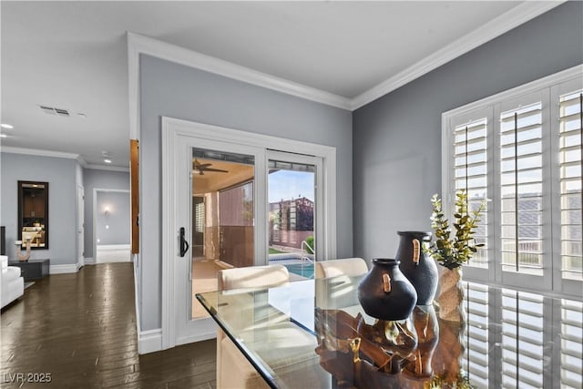 dining area featuring baseboards, visible vents, ornamental molding, and dark wood-type flooring