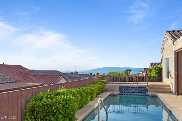 view of pool featuring a fenced backyard, a fenced in pool, and a mountain view