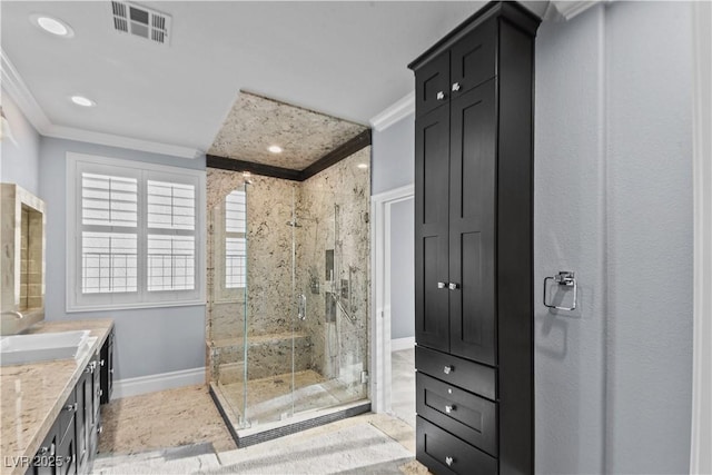 bathroom featuring vanity, a marble finish shower, baseboards, visible vents, and ornamental molding