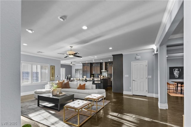 living room with baseboards, ornamental molding, dark wood-style floors, and ceiling fan