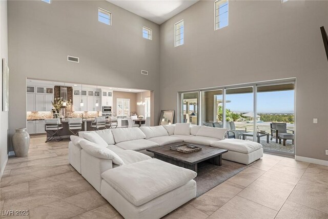 living room featuring visible vents and a towering ceiling