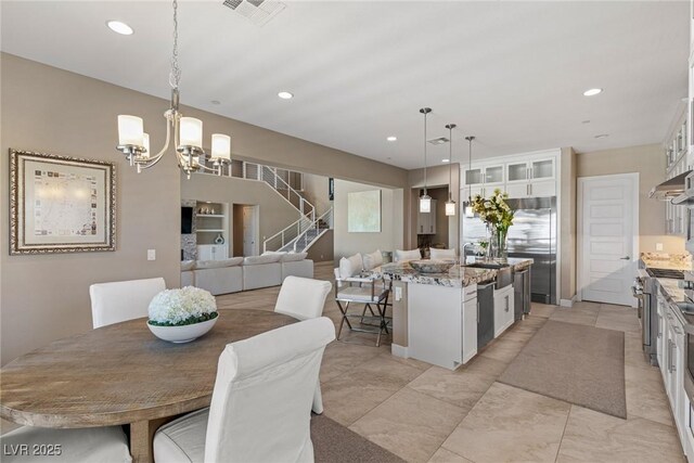 dining area featuring stairs, recessed lighting, visible vents, and an inviting chandelier